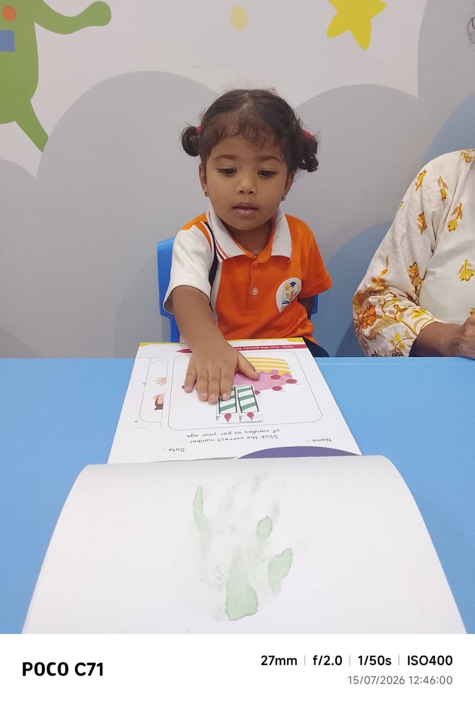 The first print on the wall — a green hand, July 2026.